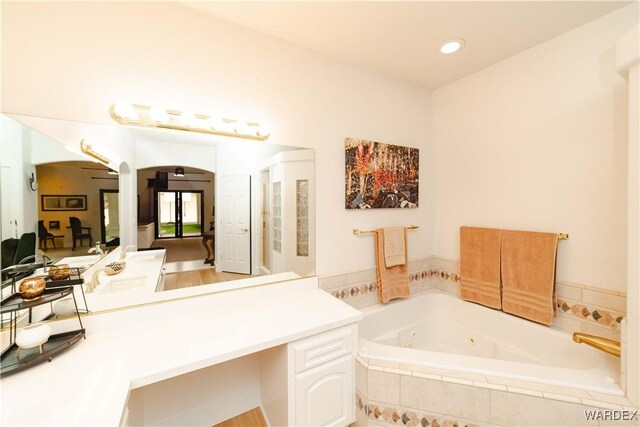 full bath featuring a tub with jets and vanity