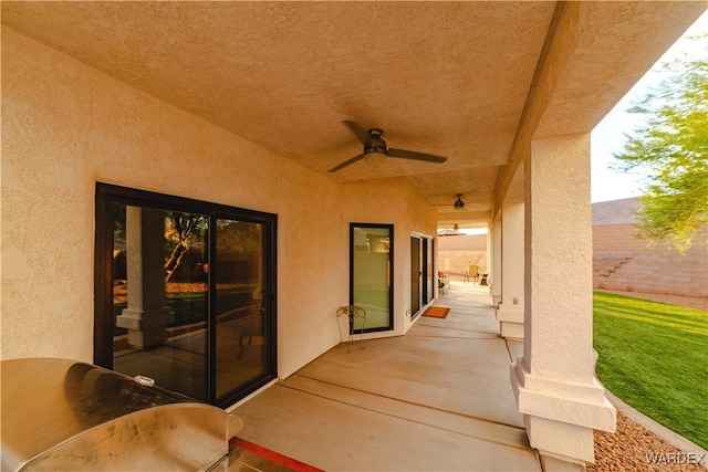 view of patio / terrace with ceiling fan and fence