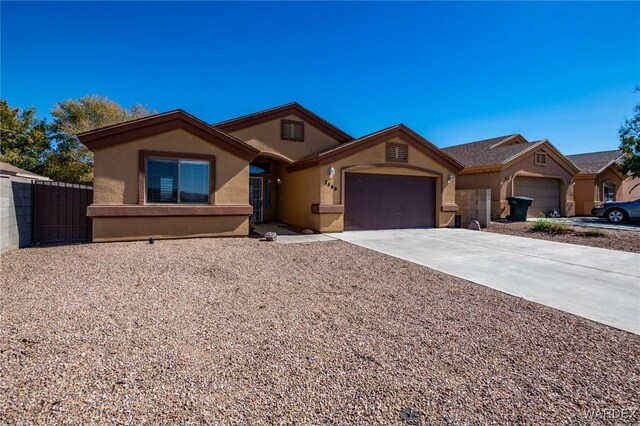 ranch-style house with a garage, driveway, fence, and stucco siding