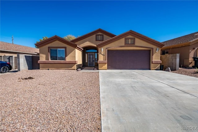 view of front facade featuring driveway, an attached garage, and stucco siding