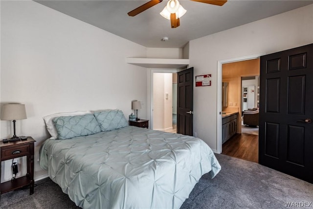 bedroom with dark wood-type flooring, baseboards, ceiling fan, and ensuite bath