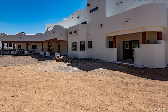 back of property featuring fence and stucco siding