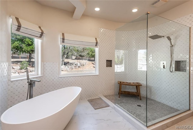 full bathroom with marble finish floor, a wainscoted wall, visible vents, a freestanding bath, and a walk in shower