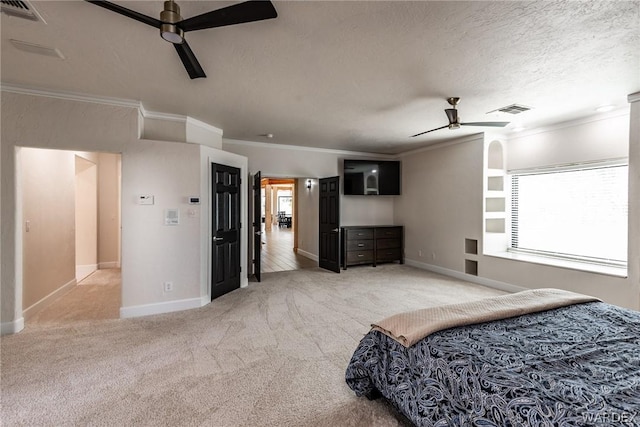 bedroom with a textured ceiling, carpet flooring, visible vents, and crown molding