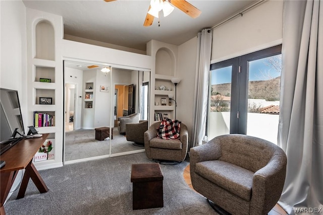 sitting room featuring ceiling fan, carpet, baseboards, and built in features