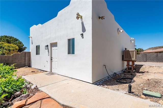 exterior space featuring a fenced backyard and stucco siding