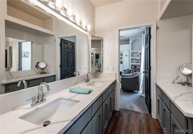 bathroom with double vanity, wood finished floors, and a sink