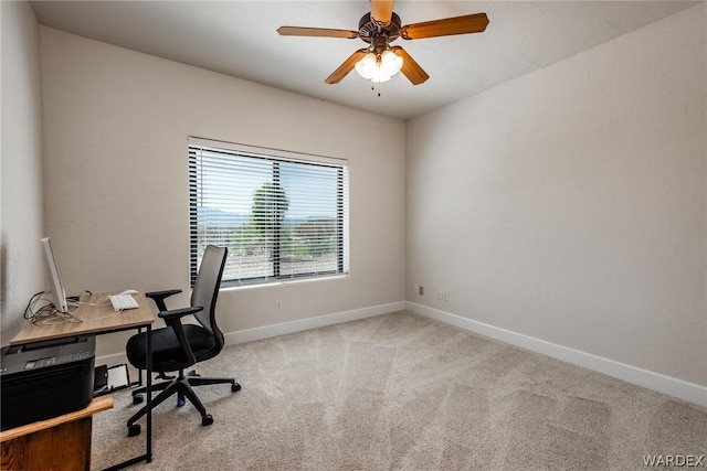 office area featuring baseboards, a ceiling fan, and light colored carpet