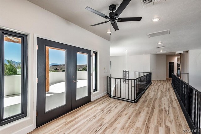 interior space with baseboards, french doors, visible vents, and light wood-style floors