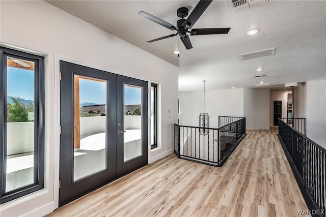 interior space with baseboards, french doors, visible vents, and light wood-style floors