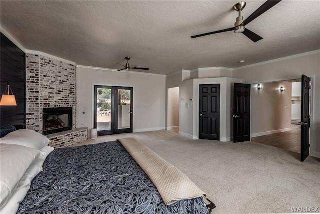 bedroom featuring access to exterior, ornamental molding, a brick fireplace, carpet flooring, and a textured ceiling