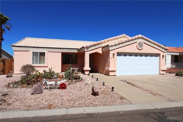 ranch-style home with driveway, a tiled roof, an attached garage, and stucco siding