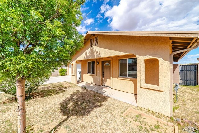 3144 N Prescott St, Kingman, AZ 86401 - view of front facade with a garage, stucco siding, and fence