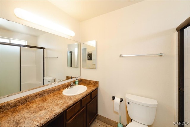 3144 N Prescott St, Kingman, AZ 86401 - full bath with toilet, baseboards, a shower with door, tile patterned flooring, and vanity