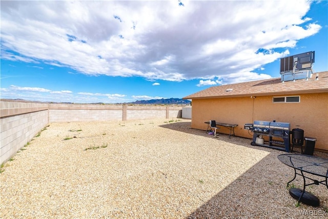 3144 N Prescott St, Kingman, AZ 86401 - view of yard with central air condition unit, a mountain view, and a fenced backyard