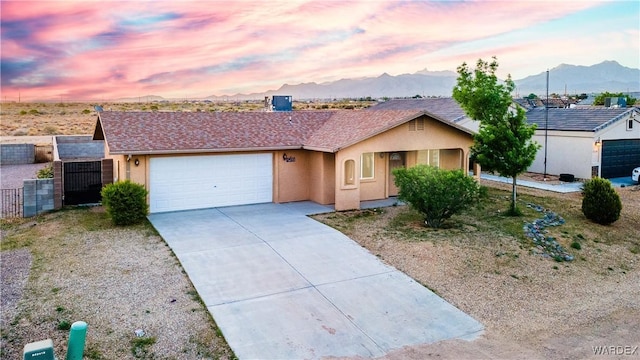 3144 N Prescott St, Kingman, AZ 86401 - single story home with stucco siding, driveway, a mountain view, and a garage