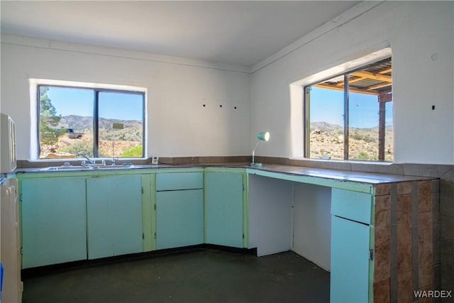 kitchen with concrete floors, a mountain view, and a sink