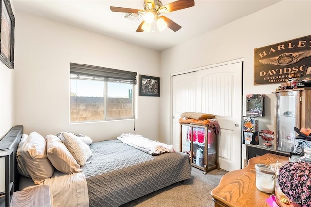 carpeted bedroom with a closet, visible vents, and ceiling fan