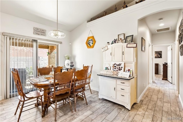 dining area featuring baseboards, visible vents, and wood finish floors