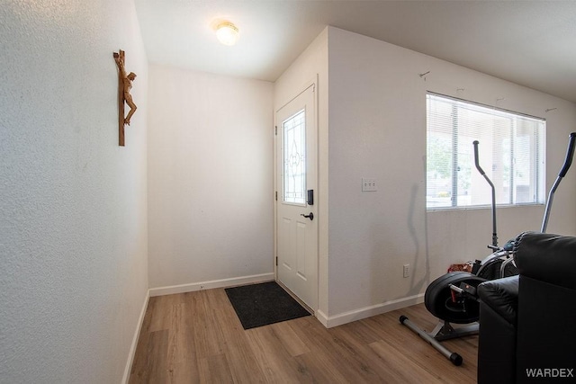 entryway featuring baseboards and wood finished floors