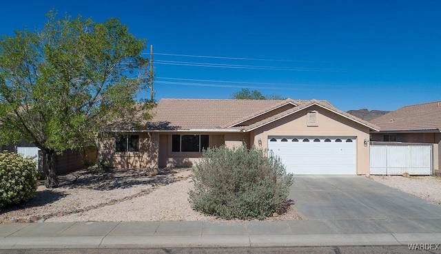 single story home featuring fence, a tiled roof, stucco siding, an attached garage, and concrete driveway