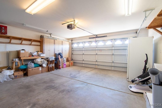 garage featuring freestanding refrigerator and a garage door opener