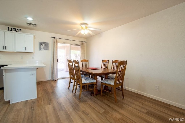 dining room with baseboards, a ceiling fan, visible vents, and light wood-style flooring