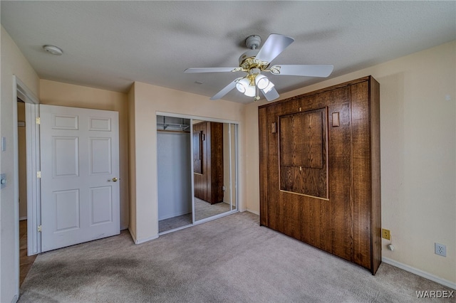 unfurnished bedroom featuring ceiling fan, carpet floors, a closet, and baseboards