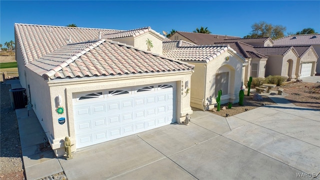 view of front facade with central air condition unit, driveway, a tile roof, and stucco siding