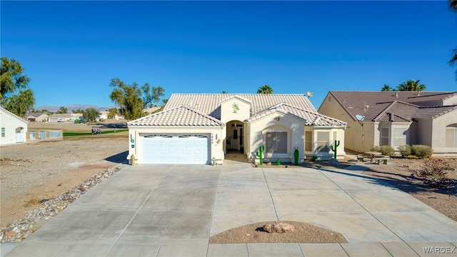 mediterranean / spanish-style home with a garage, a tile roof, driveway, and stucco siding