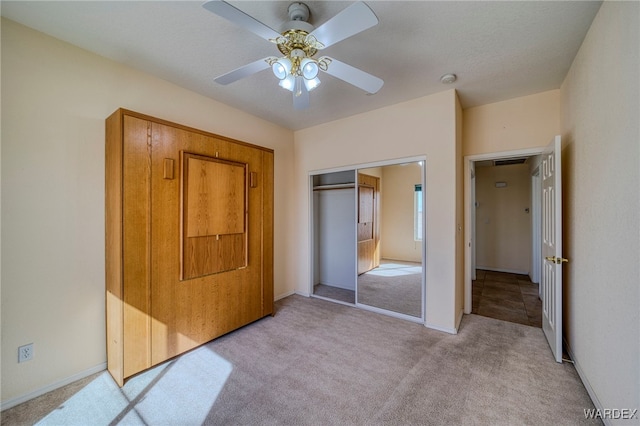 unfurnished bedroom with light carpet, visible vents, a ceiling fan, baseboards, and a closet