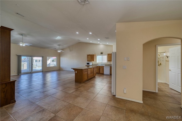 kitchen featuring arched walkways, open floor plan, visible vents, and dishwasher