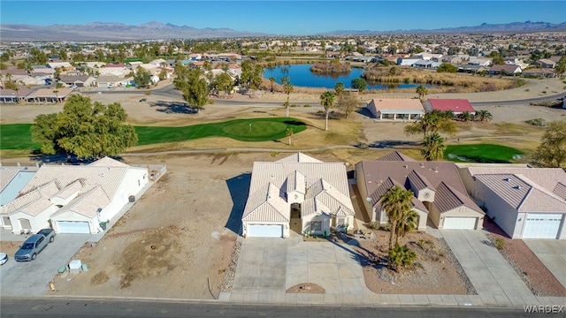 drone / aerial view featuring view of golf course, a water and mountain view, and a residential view