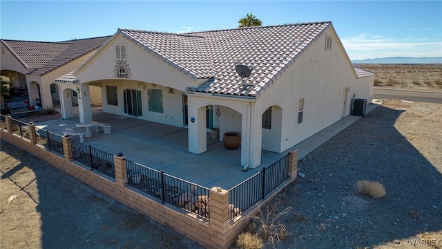 back of house featuring a tile roof, fence, cooling unit, a patio area, and stucco siding