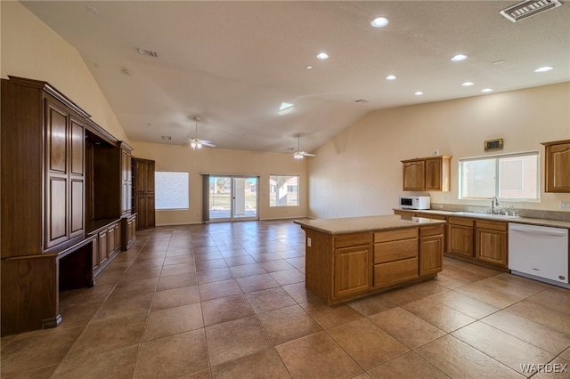 kitchen with light countertops, white appliances, a sink, and visible vents