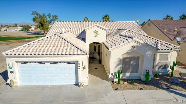 mediterranean / spanish-style home with driveway, stucco siding, an attached garage, and a tiled roof