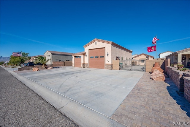 view of front of home featuring driveway, stone siding, a residential view, fence, and stucco siding