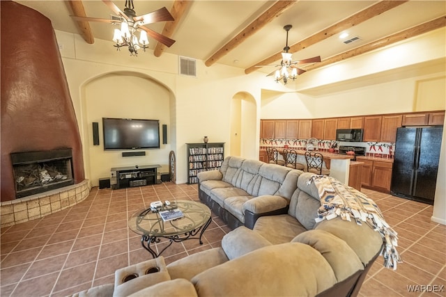 tiled living room with a large fireplace, visible vents, ceiling fan, and beamed ceiling