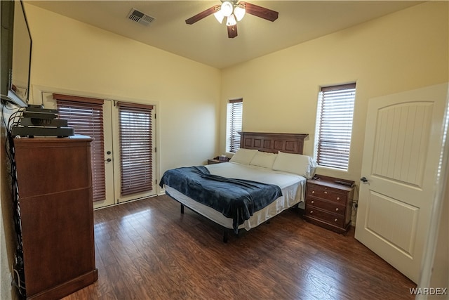 bedroom with access to outside, dark wood finished floors, visible vents, and a ceiling fan