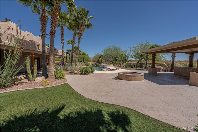 view of patio featuring an outdoor pool and a fire pit