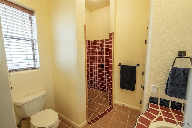 full bathroom with toilet, a shower stall, baseboards, and tile patterned floors