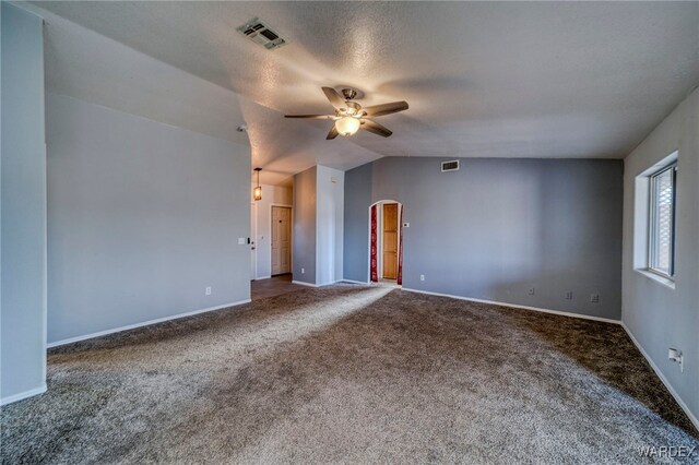 unfurnished room featuring lofted ceiling, carpet floors, visible vents, and a ceiling fan