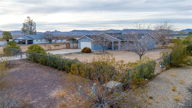 view of yard featuring a garage, a mountain view, and fence