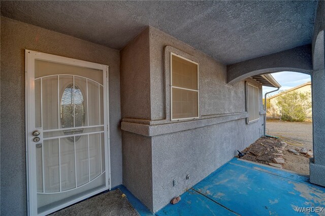 entrance to property featuring stucco siding