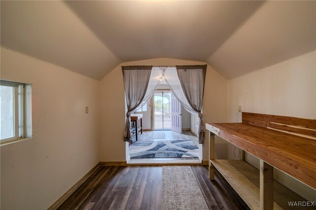 additional living space with lofted ceiling, dark wood-style floors, and baseboards