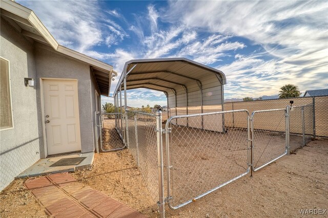 view of yard featuring a gate, fence, and a carport