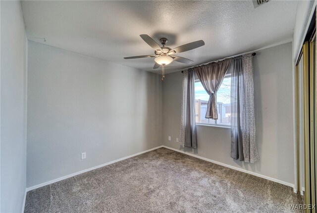 unfurnished room featuring carpet, visible vents, a ceiling fan, a textured ceiling, and baseboards