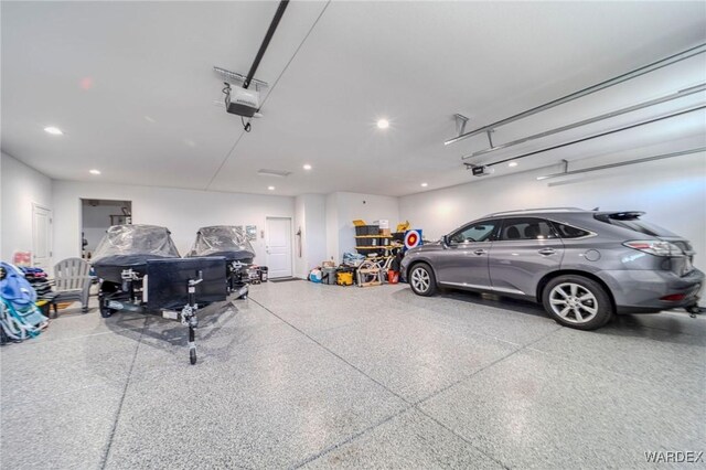 garage with recessed lighting and a garage door opener