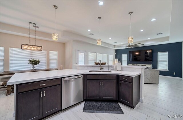 kitchen featuring a sink, open floor plan, dishwasher, and decorative light fixtures