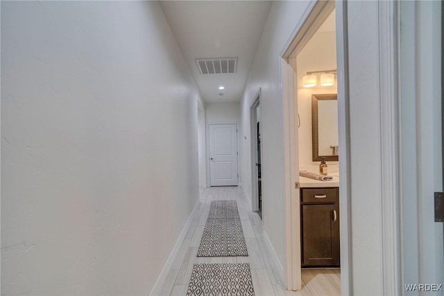 hallway featuring visible vents and baseboards